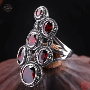 Bague argentée ornée de grenats dans un style steampunk