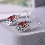 Élégance steampunk avec grenat en boucle d'oreille